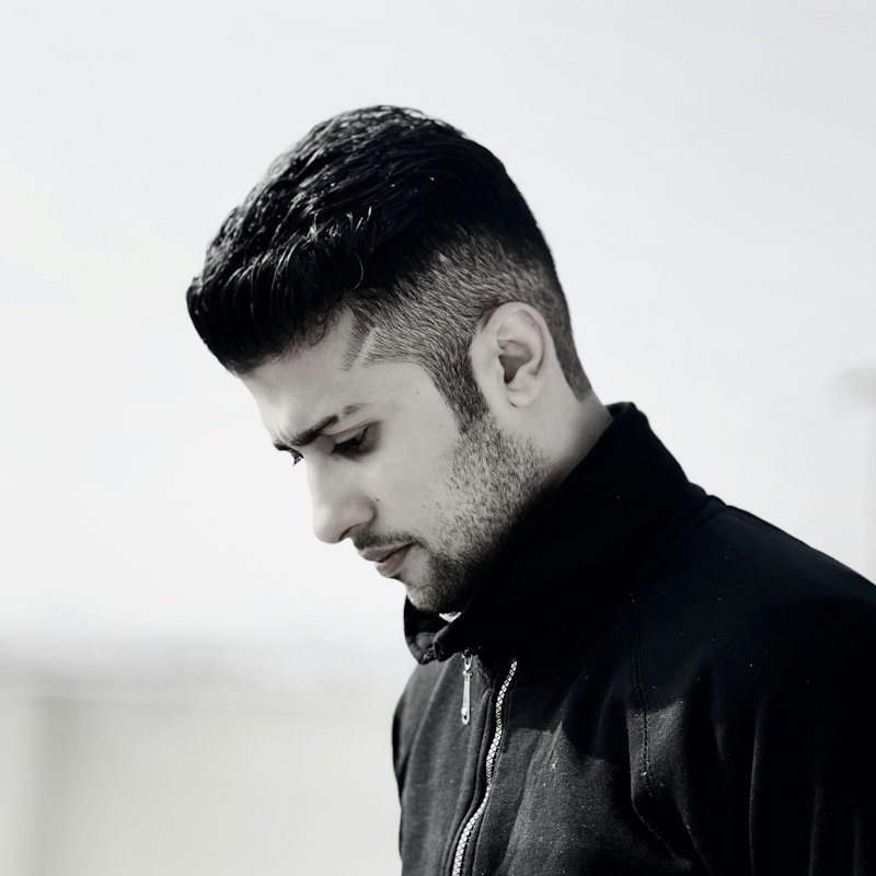 Side profile of a man with a clean high fade and textured top